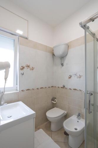 a white bathroom with a toilet and a sink at Residence O'Sole Mio Pompei in Pompei