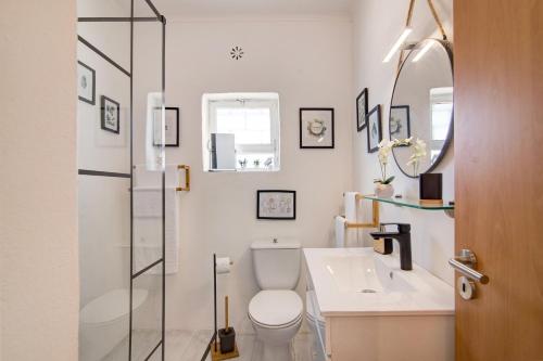 een badkamer met een toilet, een wastafel en een spiegel bij Horta Teresa in Quarteira