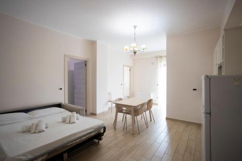 a white bedroom with a bed and a table at Residence O'Sole Mio Pompei in Pompei