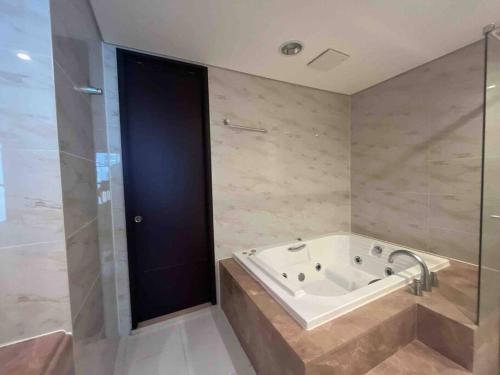 a bathroom with a tub and a glass door at Haeundae Luxury House in Busan