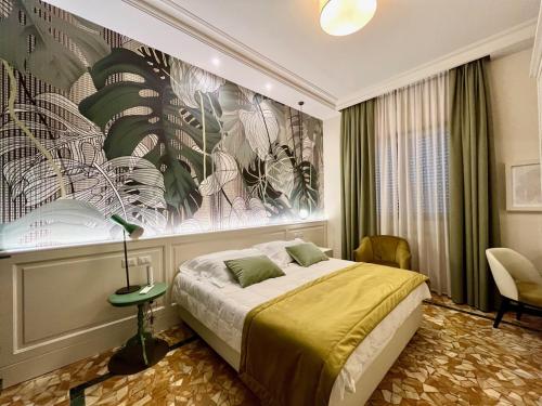 1 dormitorio con 1 cama y una gran pintura en la pared en Hotel Bellonda, en Forte dei Marmi