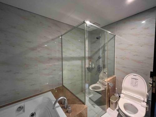 a bathroom with a shower and a toilet and a tub at Haeundae Luxury House in Busan