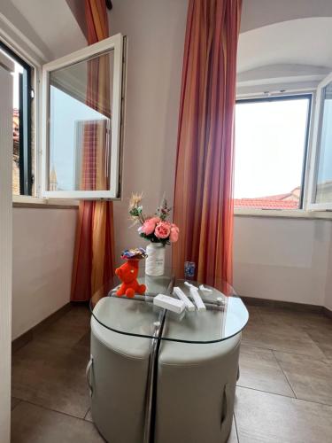Cette chambre dispose d'une table en verre et d'une fenêtre. dans l'établissement Residence Bella, à Stari Grad