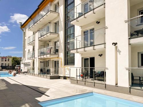 uma imagem de um edifício de apartamentos com piscina em Dobre Smaki Apartaments Chill and Food em Sarbinowo