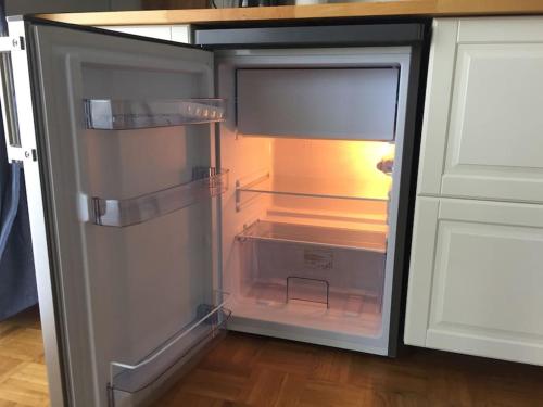 um frigorífico vazio com a porta aberta numa cozinha em Haus Magnolia 1 em Kandern
