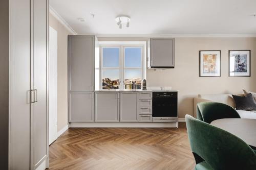 a kitchen with white cabinets and a table in a room at Enter St Elisabeth Suites & Spa in Tromsø