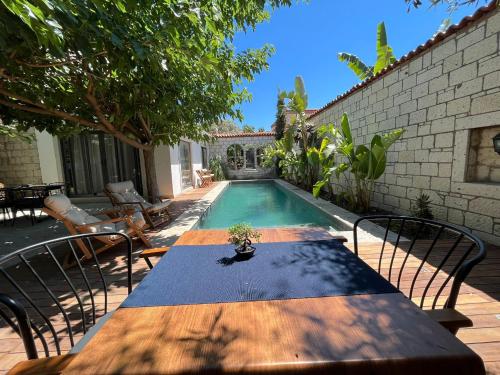 a patio with a table and a swimming pool at Armi Alaçatı in Cesme