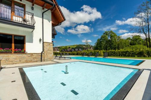 a swimming pool in the backyard of a house at Willa Skałka in Białka Tatrzanska