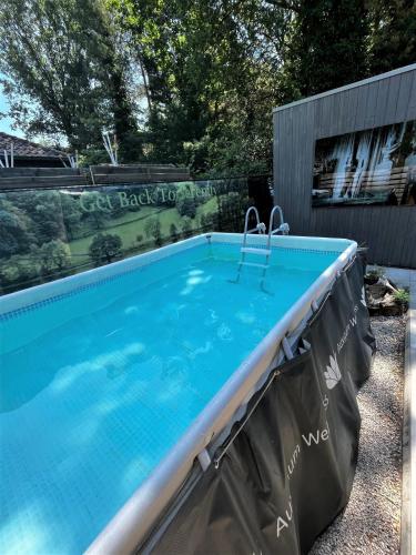 a swimming pool in a yard next to a fence at AuxiliumWellness Get Back to Serenity in Grobbendonk