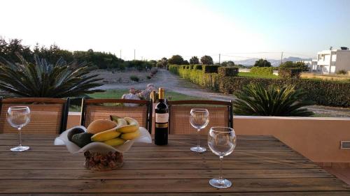a table with a bowl of fruit and wine glasses at Kos Villa - Family Comfort with large Garden, Jacuzzi in Kos