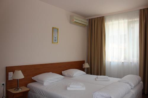 um quarto com 2 camas com lençóis brancos e uma janela em Arlanda em Sveti Vlas
