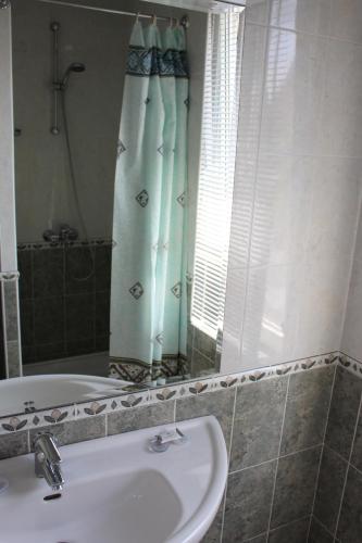 uma casa de banho com um lavatório, uma banheira e um espelho. em Arlanda em Sveti Vlas
