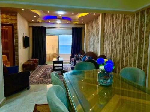 a living room with a glass table and blue chairs at سى فيو السريا in Alexandria