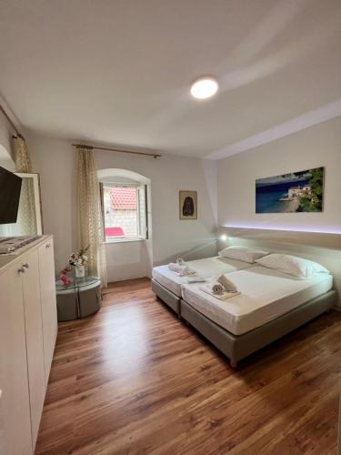 - une chambre avec un grand lit et du parquet dans l'établissement Residence Bella, à Stari Grad