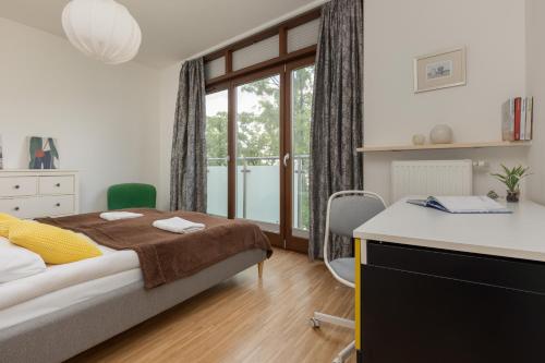 sypialnia z łóżkiem, biurkiem i oknem w obiekcie Royal Park Łazienki Apartment Warsaw Mokotów by Renters w Warszawie