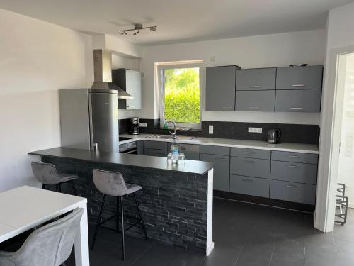 a kitchen with gray cabinets and a black counter top at Luxuswohnung direkt am Phönixsee in Dortmund