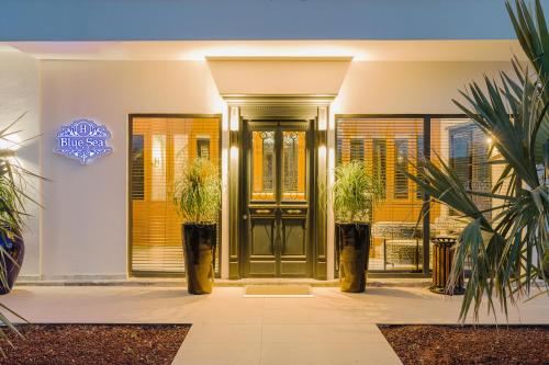 a front door of a house with potted plants at Blue Sea Karpasia Hotel in Rizokarpaso