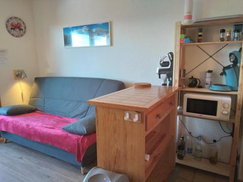 Cette chambre dispose d'un canapé et d'une table avec un four micro-ondes. dans l'établissement Studio pour 4 Pers. Proche Pistes, Parking, Casier à Skis - Crest-Voland - FR-1-733-68, à Crest-Voland