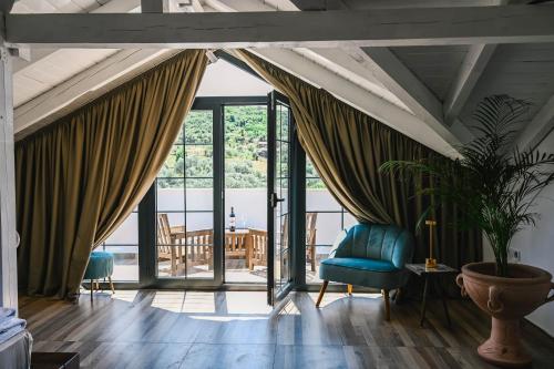 a living room with a blue chair and sliding glass doors at MASHTRA - The Olive House in Ulcinj