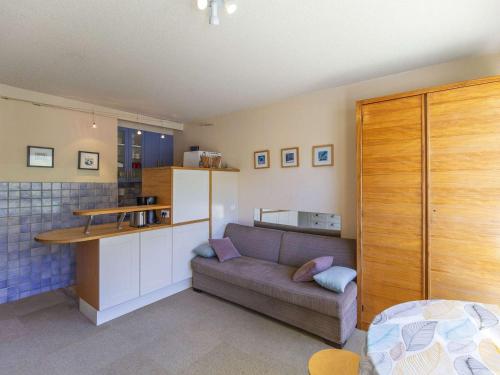 un salon avec un canapé et une cuisine dans l'établissement Studio cabine 6 personnes au pied des pistes à Gourette, séjour avec balcon, parking - FR-1-400-117, à Eaux-Bonnes