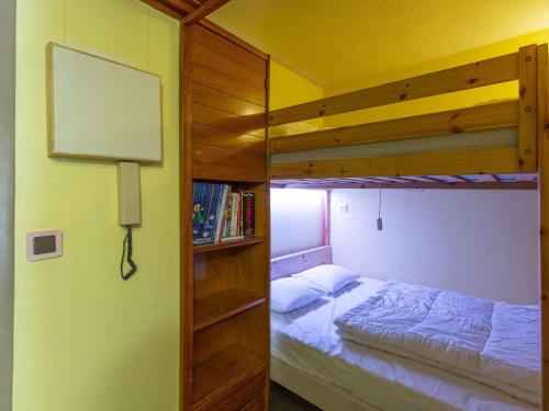 - une chambre avec des lits superposés et une étagère à livres dans l'établissement Studio cabine 6 personnes au pied des pistes à Gourette, séjour avec balcon, parking - FR-1-400-117, à Eaux-Bonnes