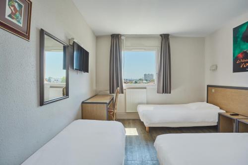 ジョアンヴィル・ル・ポンにあるHôtel Cinépole 3 étoiles Joinville le Pontのベッド2台と窓が備わるホテルルームです。