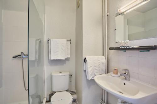 a bathroom with a toilet and a sink and a shower at Hôtel Cinépole 3 étoiles Joinville le Pont in Joinville-le-Pont