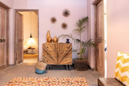a living room with a wooden cabinet and plants at The Hammock Goa in Anjuna