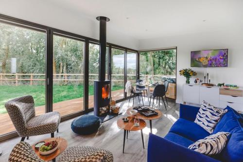 a living room with a blue couch and a fireplace at Eco Lodge "Deben" with Private Hot Tub in East Bergholt