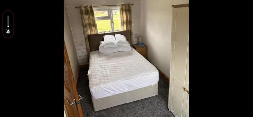 a small bedroom with a bed and a window at D5 Rickardos Holiday Lets in Mablethorpe