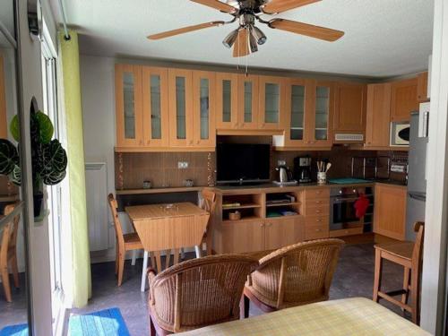 une cuisine avec une table et un ventilateur de plafond dans l'établissement Studio lumineux avec balcon, proche centre-ville et cures, parking inclus, idéal pour 2 personnes - FR-1-703-155, à Amélie-les-Bains-Palalda