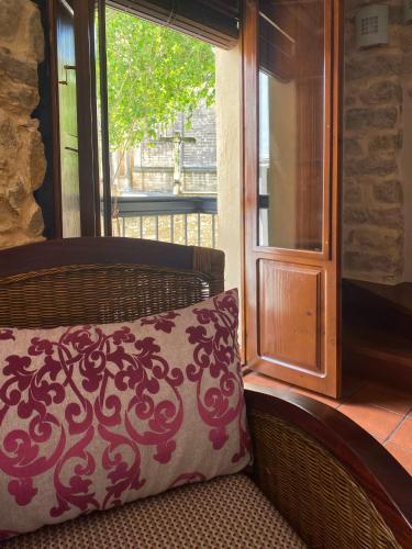 a pillow sitting on a couch in front of a window at Balcones con Encanto - vistas al conjunto monumental Patrimonio de la Humanidad in Úbeda