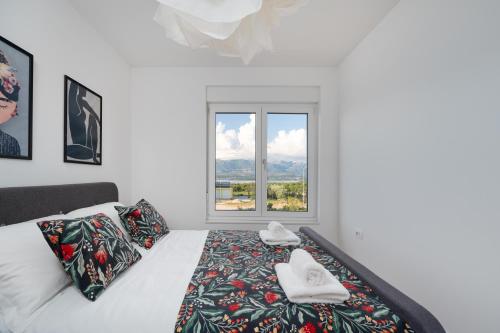 a white bedroom with a bed with a window at Villa Dream Island in Paljuv