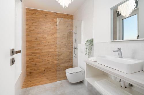 a bathroom with a toilet and a sink and a shower at Villa Dream Island in Paljuv