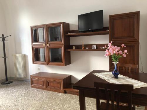 una sala da pranzo con tavolo e vaso di fiori di Casa La Noria a Mola di Bari