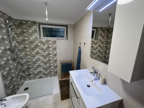 een badkamer met een wastafel, een douche en een toilet bij Apartment Hermes in Lovran