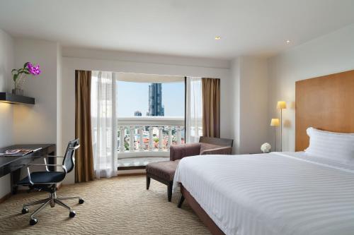 a hotel room with a bed and a desk and a window at lebua at State Tower in Bangkok