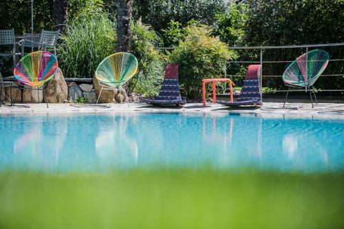 un grupo de sillas sentadas junto a una piscina en Paloria Apartments & Sport, en Lagundo