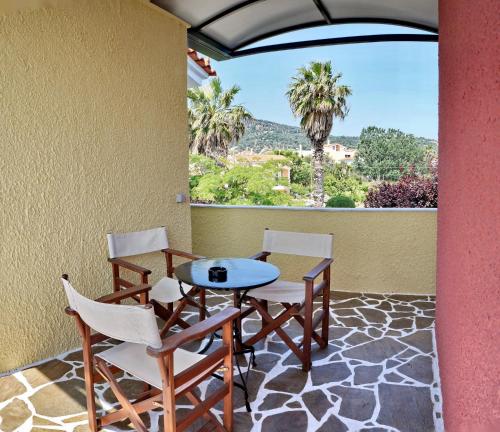 a table and chairs on a patio with a view at Heliatoras Studios in Loutrópolis Thermís