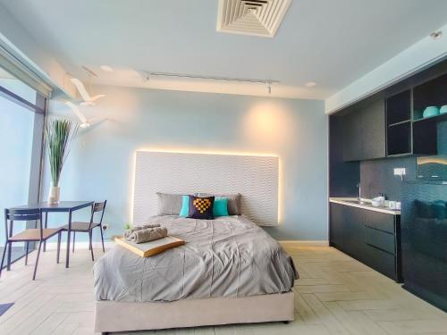 a bedroom with a large bed and a table at Empire City PJ Studio Suites by Manhattan Group in Petaling Jaya
