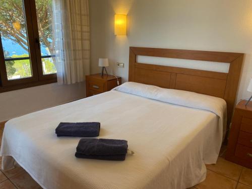 a bedroom with a bed with two towels on it at Apartamento con espectaculares vistas al Mediterráneo in Calella de Palafrugell