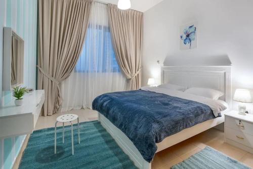 a bedroom with a large bed with a blue blanket at BEST 2 Bedroom Apartment Beach Front (Side View) in Abu Dhabi