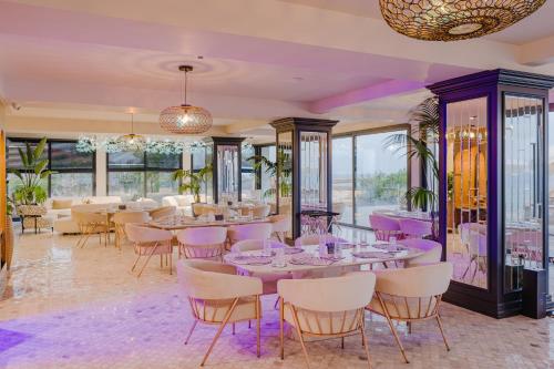 a dining room with purple tables and chairs at Blue Sea Karpasia Hotel in Rizokarpaso