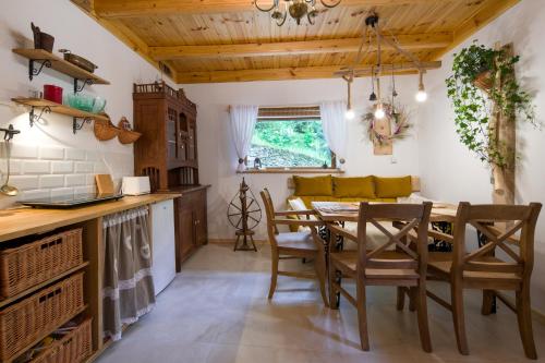 a kitchen and dining room with a table and chairs at Świt w Gorcach - dom wakacyjny in Ochotnica Dolna