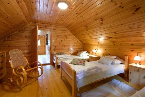 a bedroom with two beds in a log cabin at Świt w Gorcach - dom wakacyjny in Ochotnica Dolna