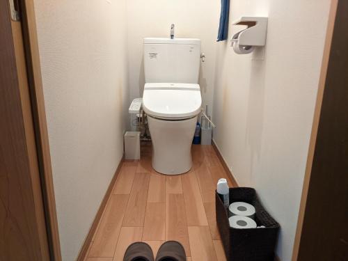 a small bathroom with a toilet in a hallway at Guesthouse Tomaru in Takayama