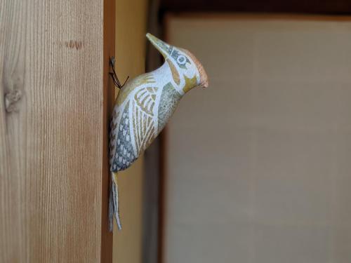 a figurine of a bird hanging on a door at Guesthouse Tomaru in Takayama