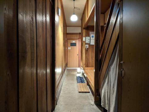 a hallway with wooden walls and a hallway with at Guesthouse Tomaru in Takayama