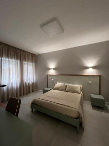 a bedroom with a large bed and a window at Stanze d’Autore in Taranto