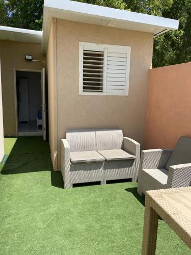 a patio with two wicker chairs and a window at פרטיות וחוויה אצל יעקב וירדנה Privacy and an experience at Jacob and Yardena in Afula